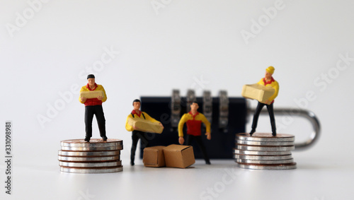 Miniature courier standing on a pile of coins with a lock.