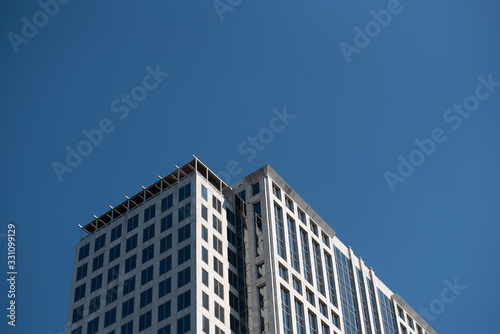 Looking up at a tall building top, with blank empty room space at top for copy