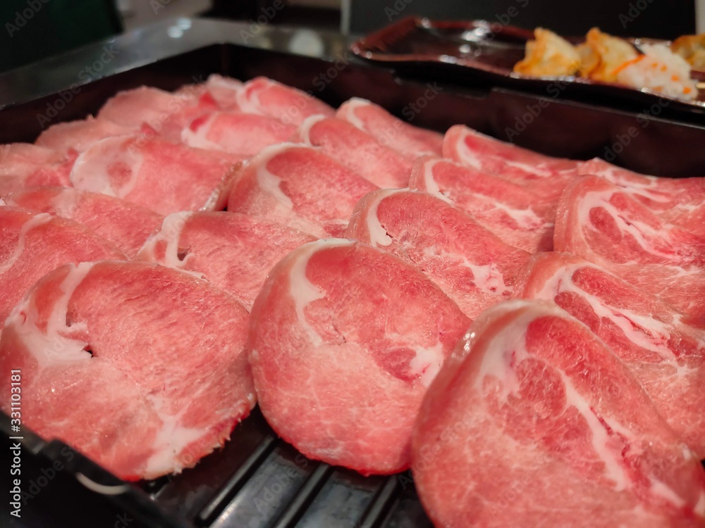 Fresh pork sliced for japanese hot pot on black plate