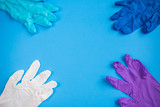 Flat lay composition with multicolor medical gloves in the corners on blue background. Virus protection
