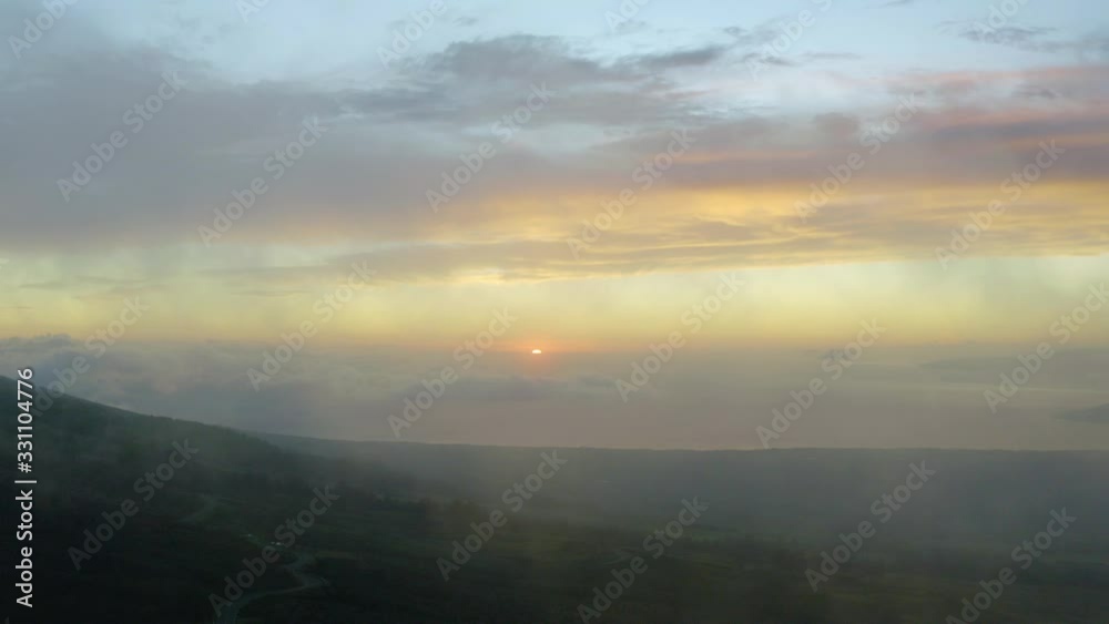 Aerial, tracking, drone shot of sunset turning to dusk, above mountains, clouds and the Pacific ocean, in Maui, Hawaii, USA Aerial, tracking, drone shot of sunset turning to dusk, above mountains, clouds and the Pacific ocean, in Maui, Hawaii, USA
