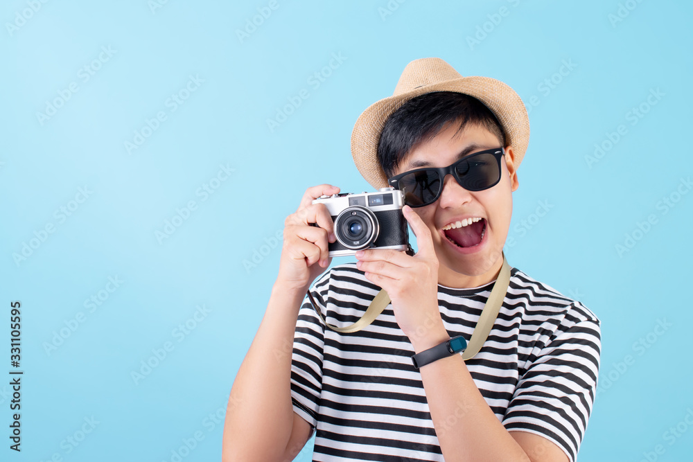 Happy Asian tourists are taking pictures in the studio on a blue background. Happy Asian tourists are taking pictures in the studio on a blue background.