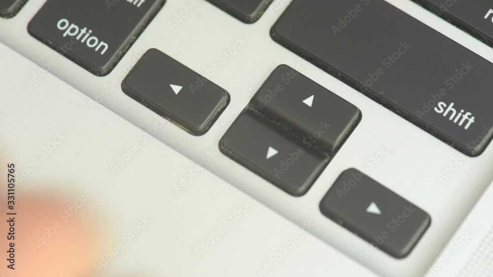 Fingers playing with the arrow keys on the laptop keyboard.