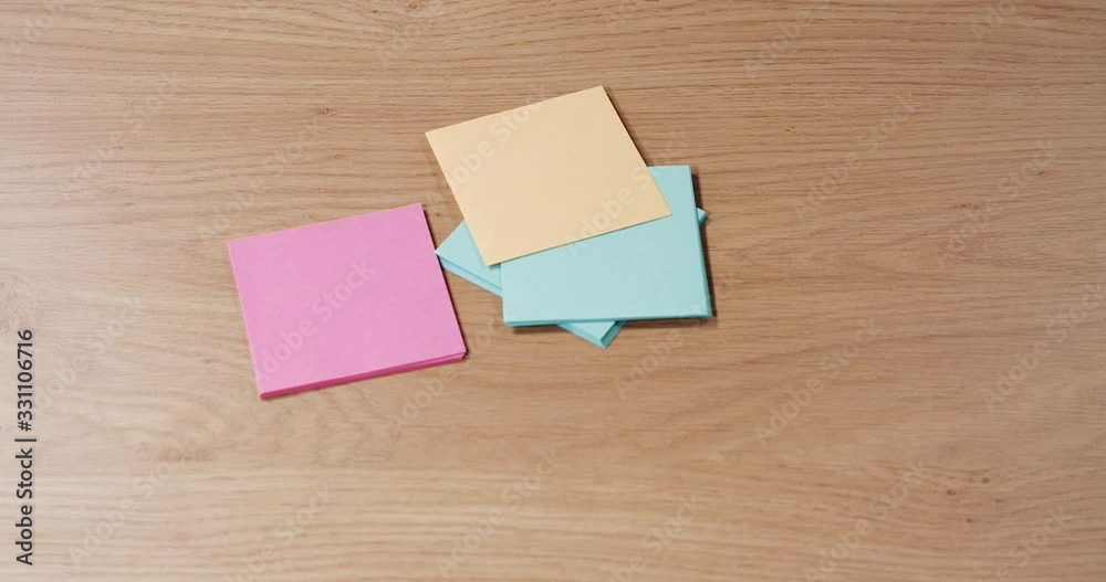 several colours of notes and post its dropping on a desk, close up several colours of notes and post its dropping on a desk, close up