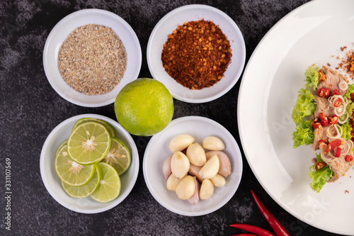 Spicy pork salad with galangal, lemon, chilli, garlic and put in a salad on a white plate.