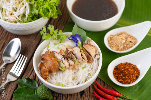 Chicken noodle in a bowl with side dishes, Thai food