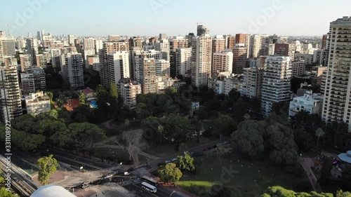 Aerial view of the skyline and buildings around Barracas de Belgrano park in Buenos Aires, Argentina. Drone flying forward during sunset