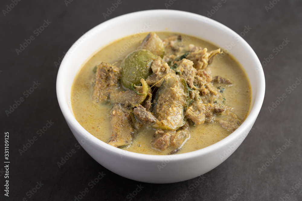 Chicken green curry in a white cup on the cement ground Chicken green curry in a white cup on the cement ground