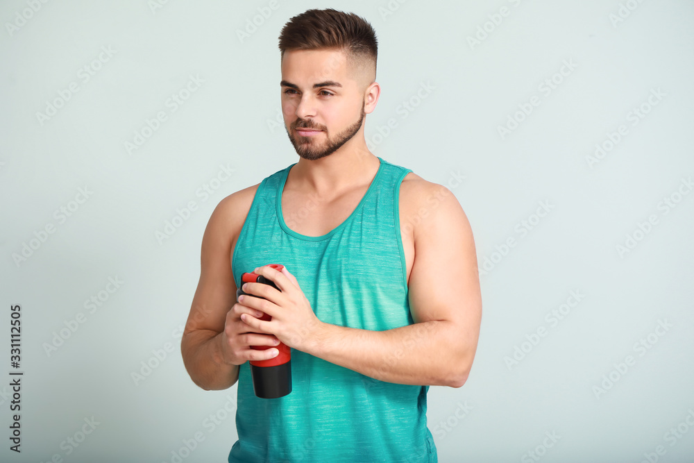 Sporty man with protein shake on light background Sporty man with protein shake on light background