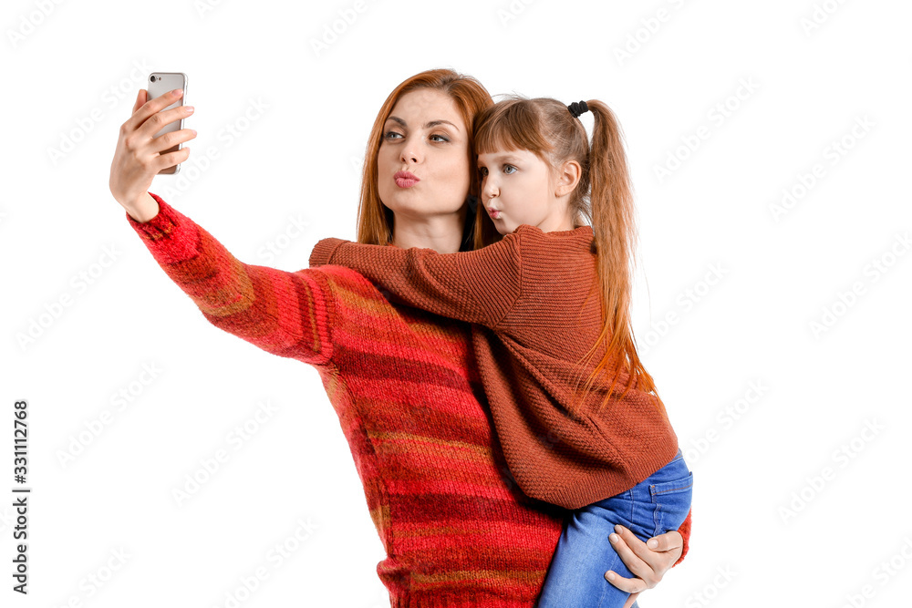 Mother and her little daughter taking selfie on white background Mother and her little daughter taking selfie on white background