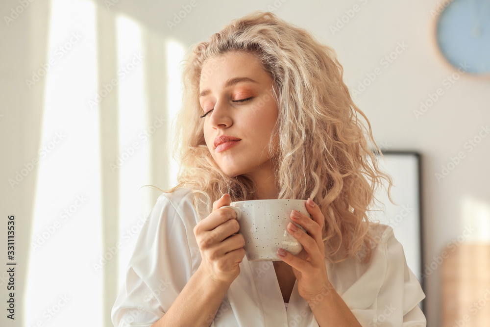 Morning of beautiful young woman drinking coffee in bedroom