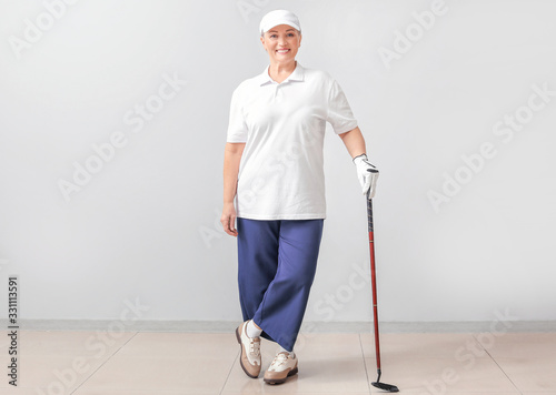 Sporty mature golfer near l...