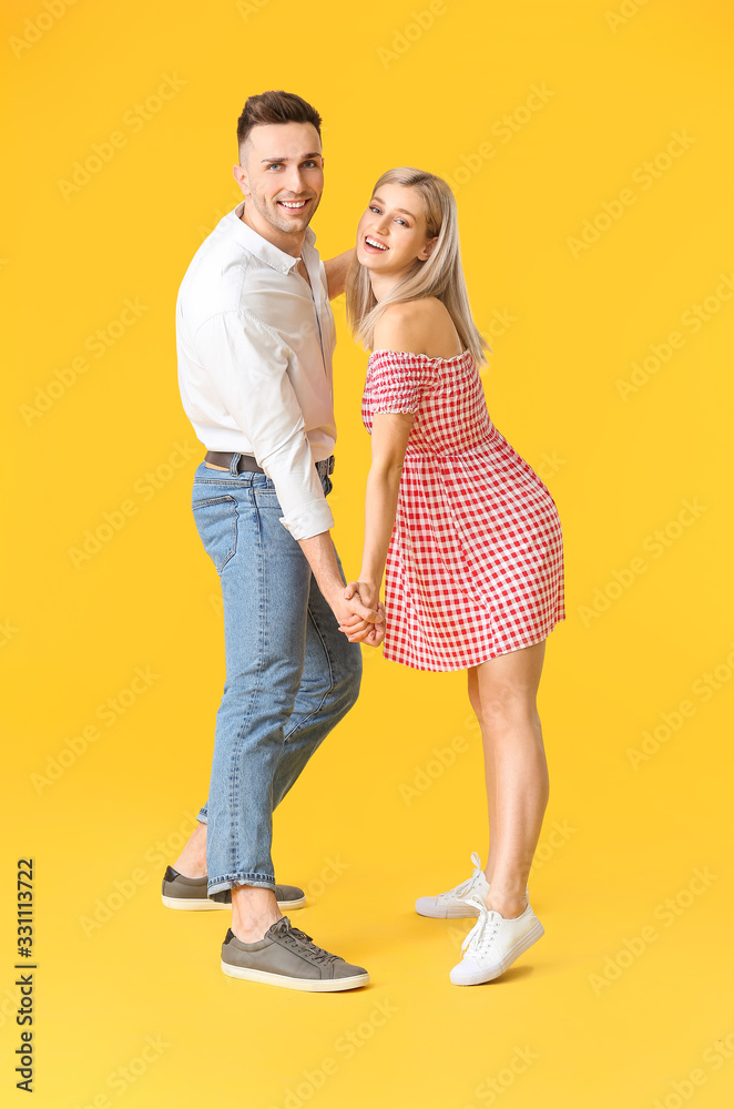 Happy dancing young couple on color background Happy dancing young couple on color background