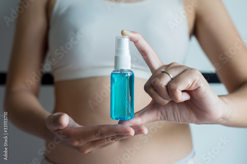 Woman hands holding sanitizer gel in spray bottle for hand hygiene coronavirus protection