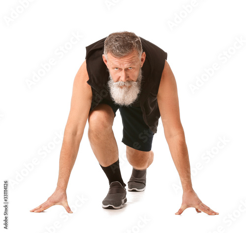 Elderly man in crouch start position on white background