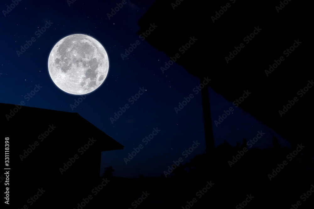 Full moon at night with silhouette house.