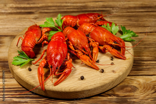 Boiled crayfish on cutting board on wooden table