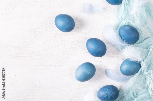 Colorful easter eggs with feathers on light background