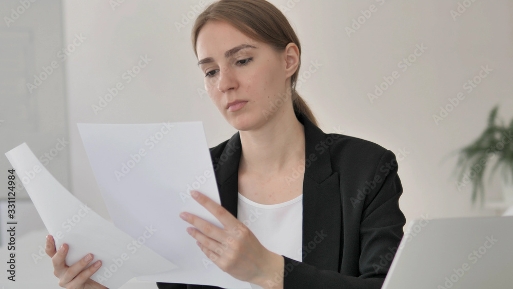 Young Businesswoman Reading Contract at Work Young Businesswoman Reading Contract at Work