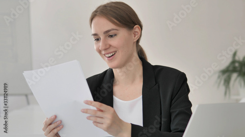 Young Businesswoman Reading Documents at Work