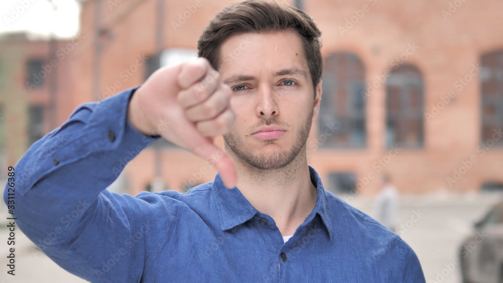 Thumbs Down by Young Man Standing Outdoor Thumbs Down by Young Man Standing Outdoor