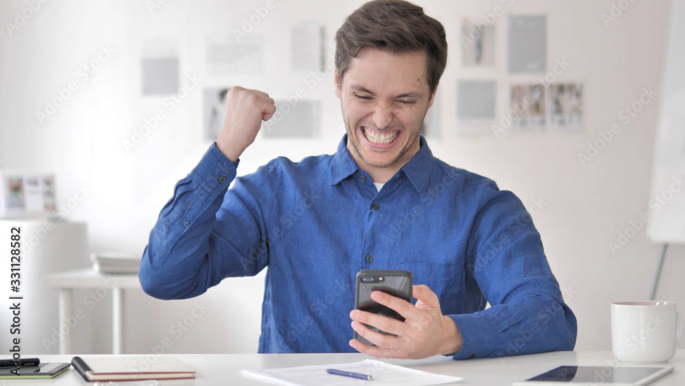Casual Adult Man Celebrating Success on Smartphone Casual Adult Man Celebrating Success on Smartphone