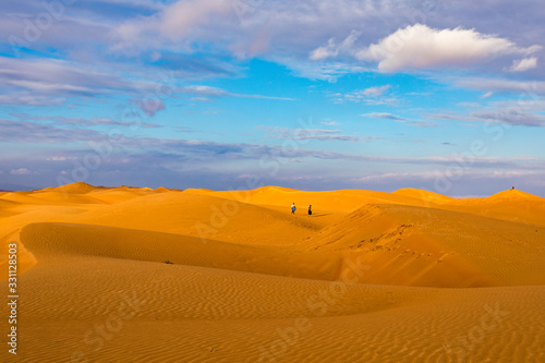 Wahiba Sand desert landscape of Sultanate of Oman - Curvy sand dunes pattern at sunset with cloudy sky.