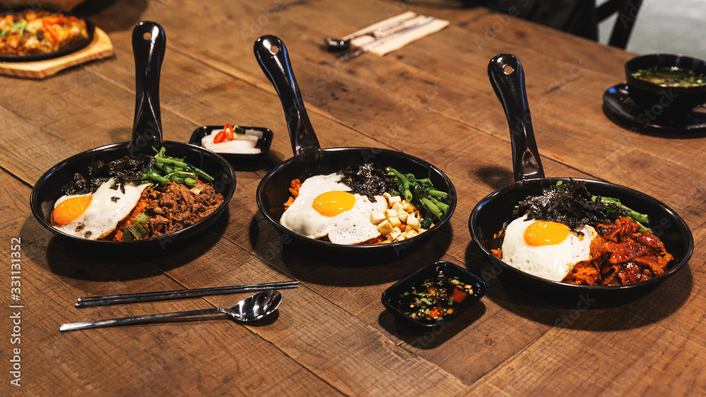 Φωτογραφία Bibimbap (Korean rice mixed with kimchi pork, tofu, seaweed and stir fried vegetables topping with sesame) served on the hot pan