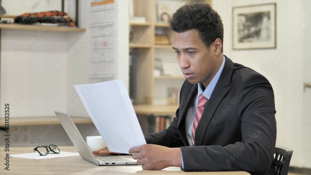 Young African Businessman Reading New Contract at Work Young African Businessman Reading New Contract at Work