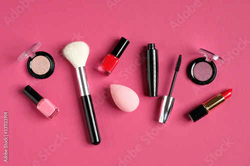 Set of decorative makeup cosmetic products on pink background. Flat lay, top view. Beauty and fashion concept.