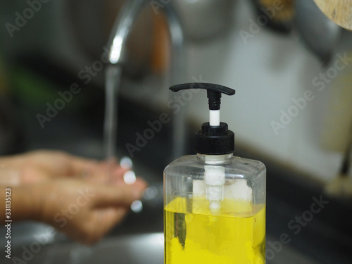 OLYMPUSA woman standing and washing her hands at the sink to prevent germs protect colona virus, covid 19  DIGITAL CAMERA photo