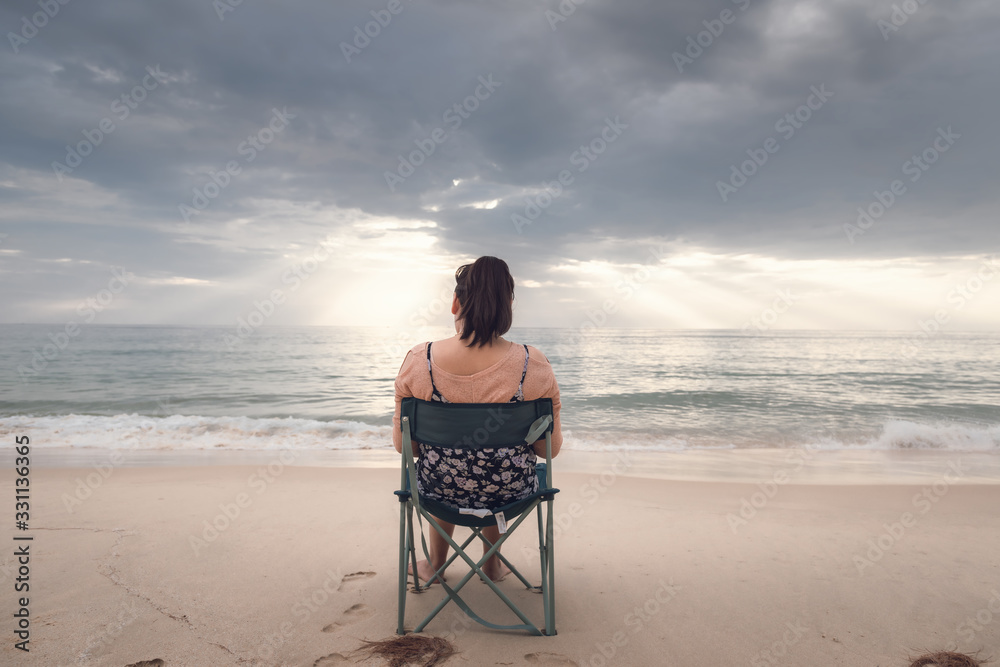 Freelancer Woman is Working on Tablet While Travel Vacation Trip at The Beach, Smart Woman is Using Tablet for Communication and Entertainment at Outdoor Sand Beach. Freelance and Relaxation Concept.