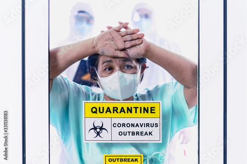 Coronavirus covid 19 infected female patient in a quarantine room with a sign of quarantine coronavirus covid 19 outbreak with blurred coronavirus disease control experts behind background