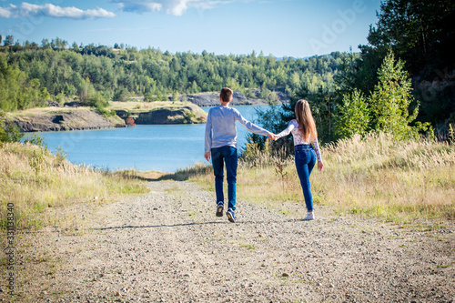 young couple walking in nature near lake