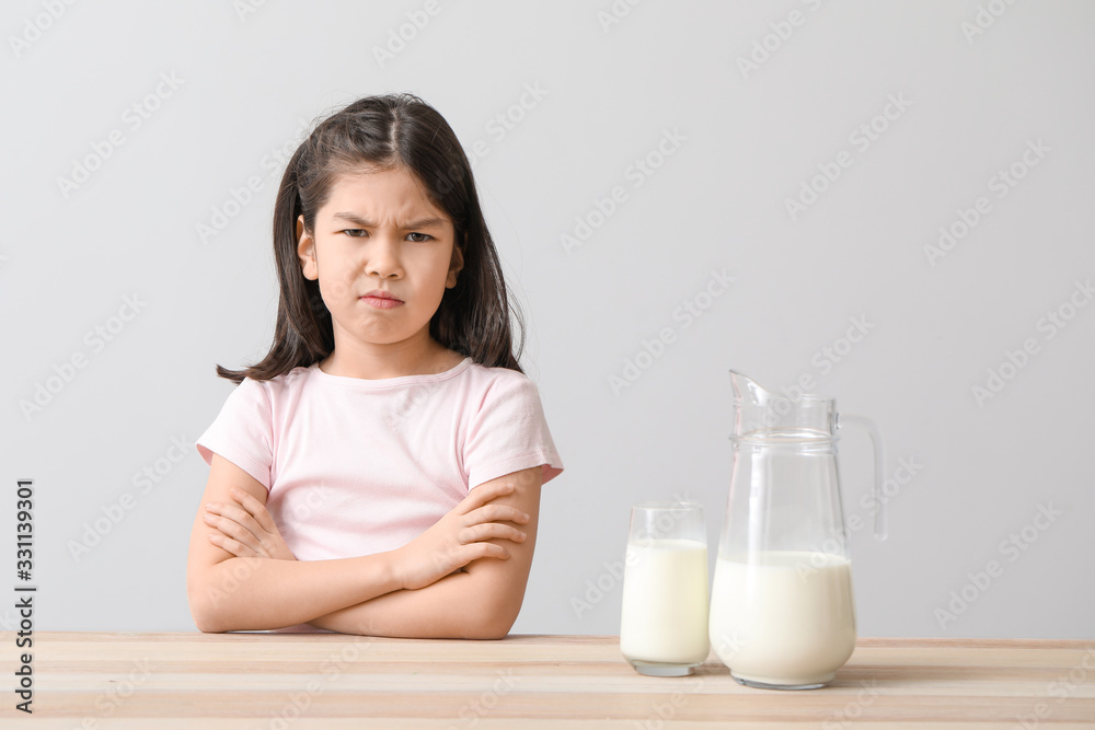 Cute Asian girl with dairy allergy on light background Cute Asian girl with dairy allergy on light background