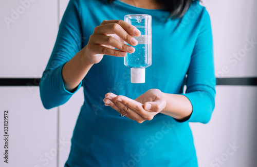 Woman hands holding sanitizer gel in bottle for hand hygiene coronavirus protection at home