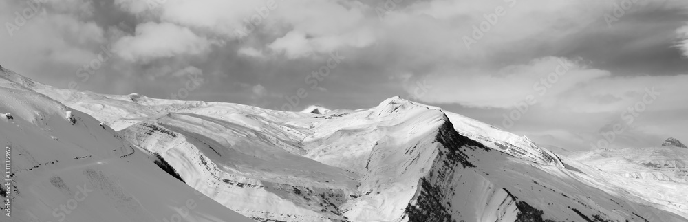 Panorama of snowy winter mountains and sky with clouds