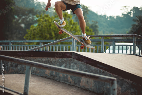 Skateboarder legs skating at skatepark