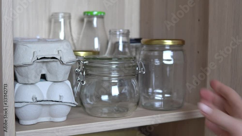 Empty reusable glass jars, bottles, eggs boxes for sustainable food storage, zero waste kitchen.