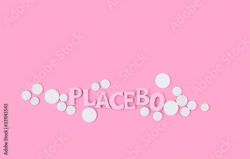 white Pills and word "placebo" on pink background. Placebo effect, fake medical treatment. minimal creative concept. copy space © Ju_see