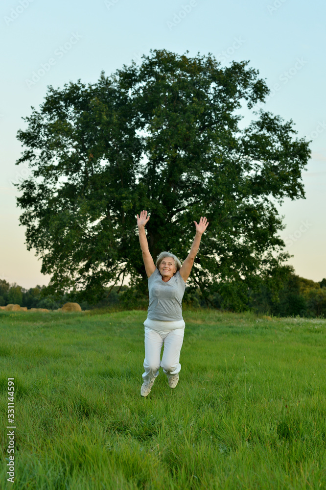 Mature woman jumping on fresh air in summer Mature woman jumping on fresh air in summer