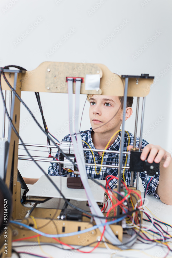 Education, children, technology concept - teen boy is printing on 3d ...