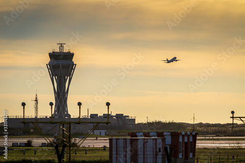 Torre de control y avión despegando en el aeropuerto de Barcelona