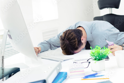 Very shocked, distraught or very tired, unhappy businessman in confident shirt, with desktop computer at office. Business, job and education concept.