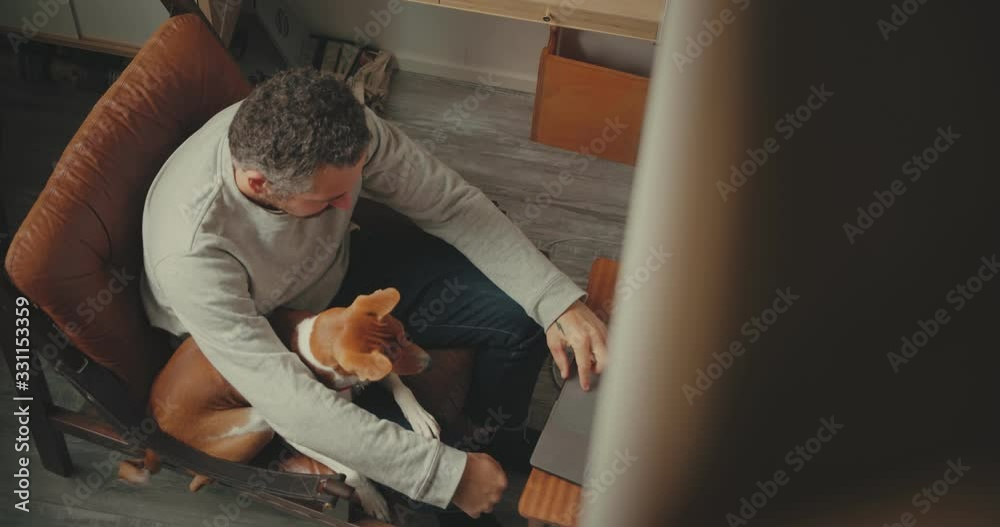 Adult modern age man, creative professional or office worker enjoys time at home. Work remotely during involuntary self isolation in quarantine. Comfortable work environment from comfort of own house