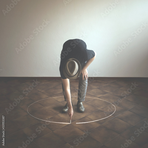 man drawing white circle  around him with chalk, abstract concept