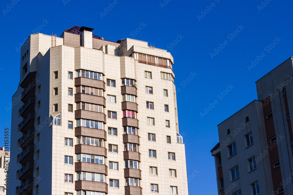 Obraz premium Multi-storey residential buildings in the city against the blue sky.