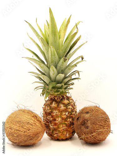 Ripe pineapple and coconuts closeup isolated on white background photo