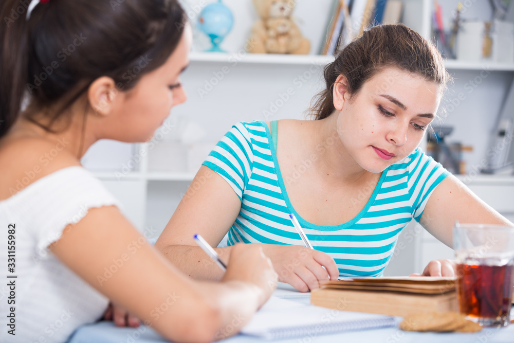 Teens girls doing homework and discussing