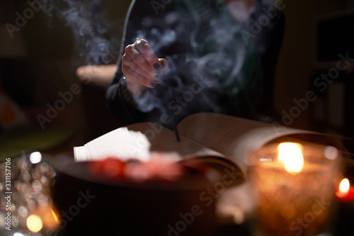 Close-up of fortune-teller's hands, predictions books, smoke